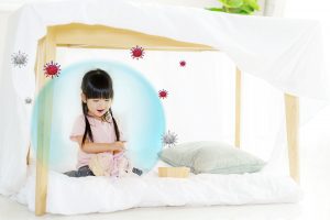 asian cute little girl play her doll while sitting blanket fort living room home
