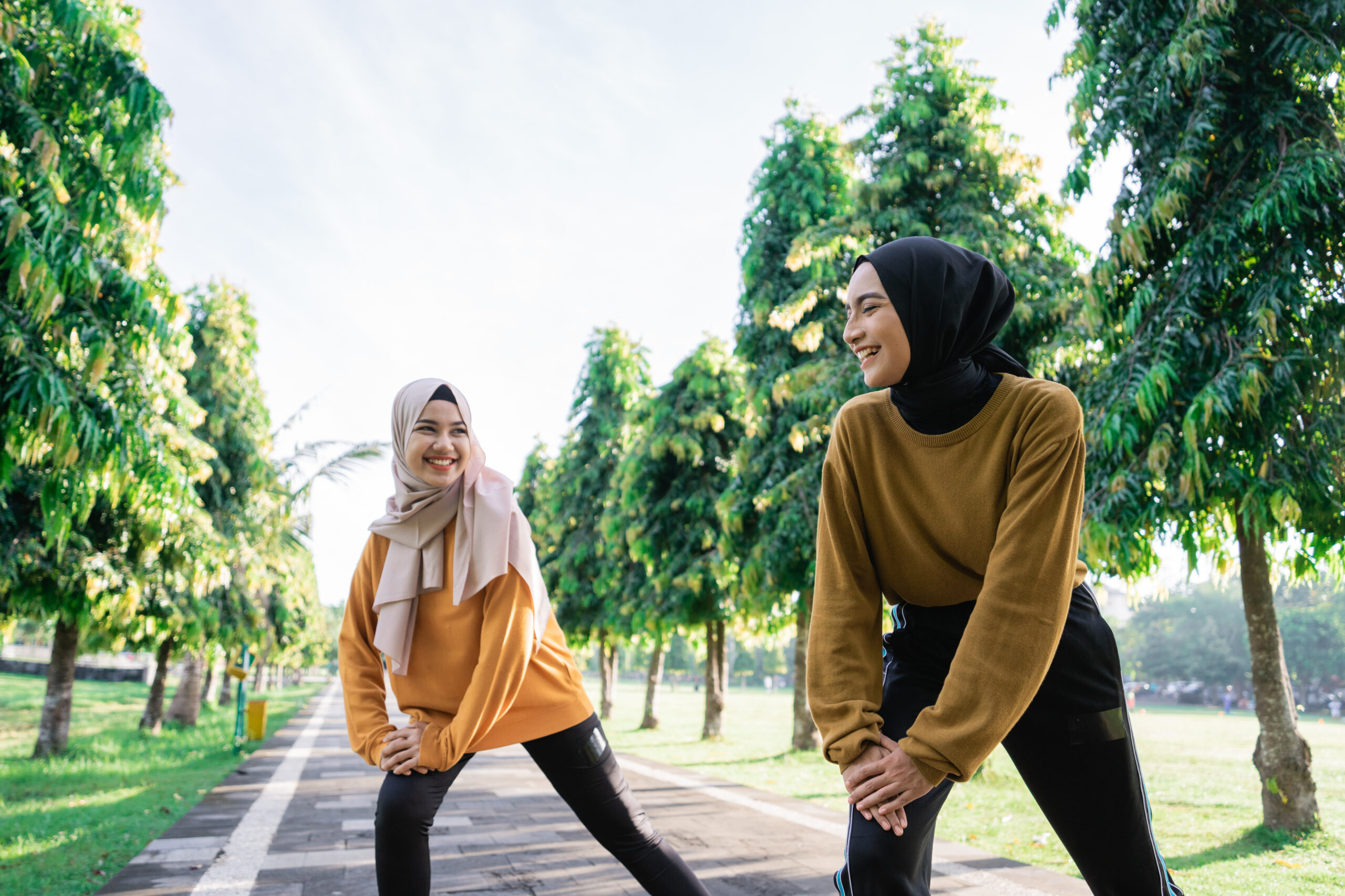 two happy muslim girls headscarves lunges before jogging outdoor sports scaled