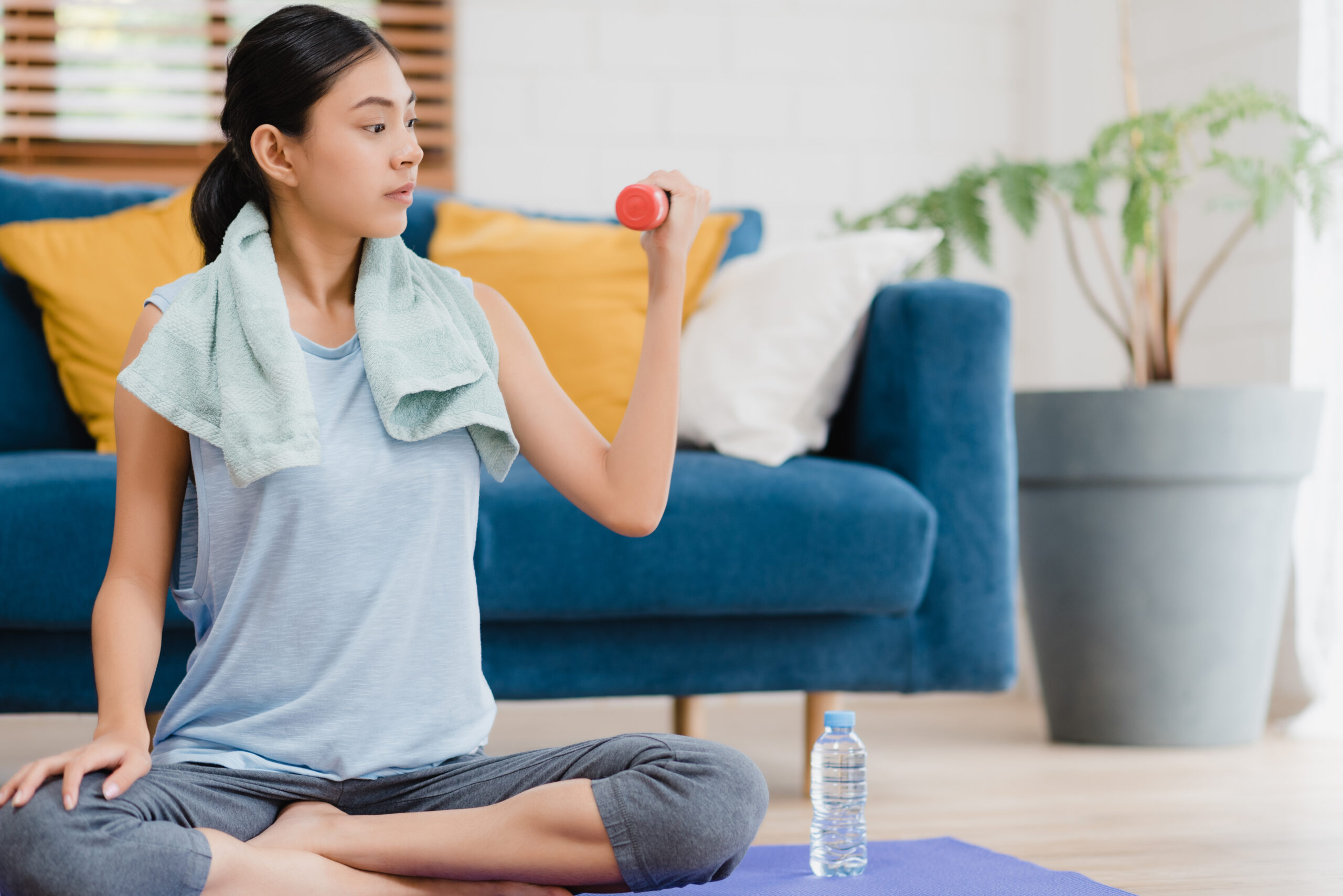 young asian woman practicing yoga living room scaled